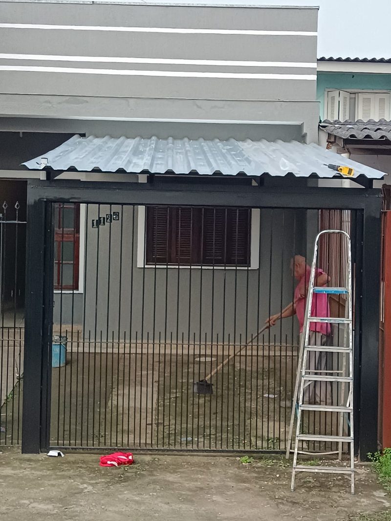 Cobertura metálica na entrada de casa, com grade e portão